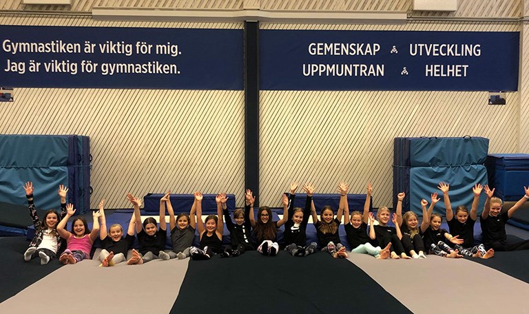 Barn med händerna upp i luften i träningslokal