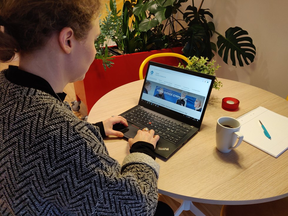 Person vid laptop, skärmen visar gymnastikförbundets sida