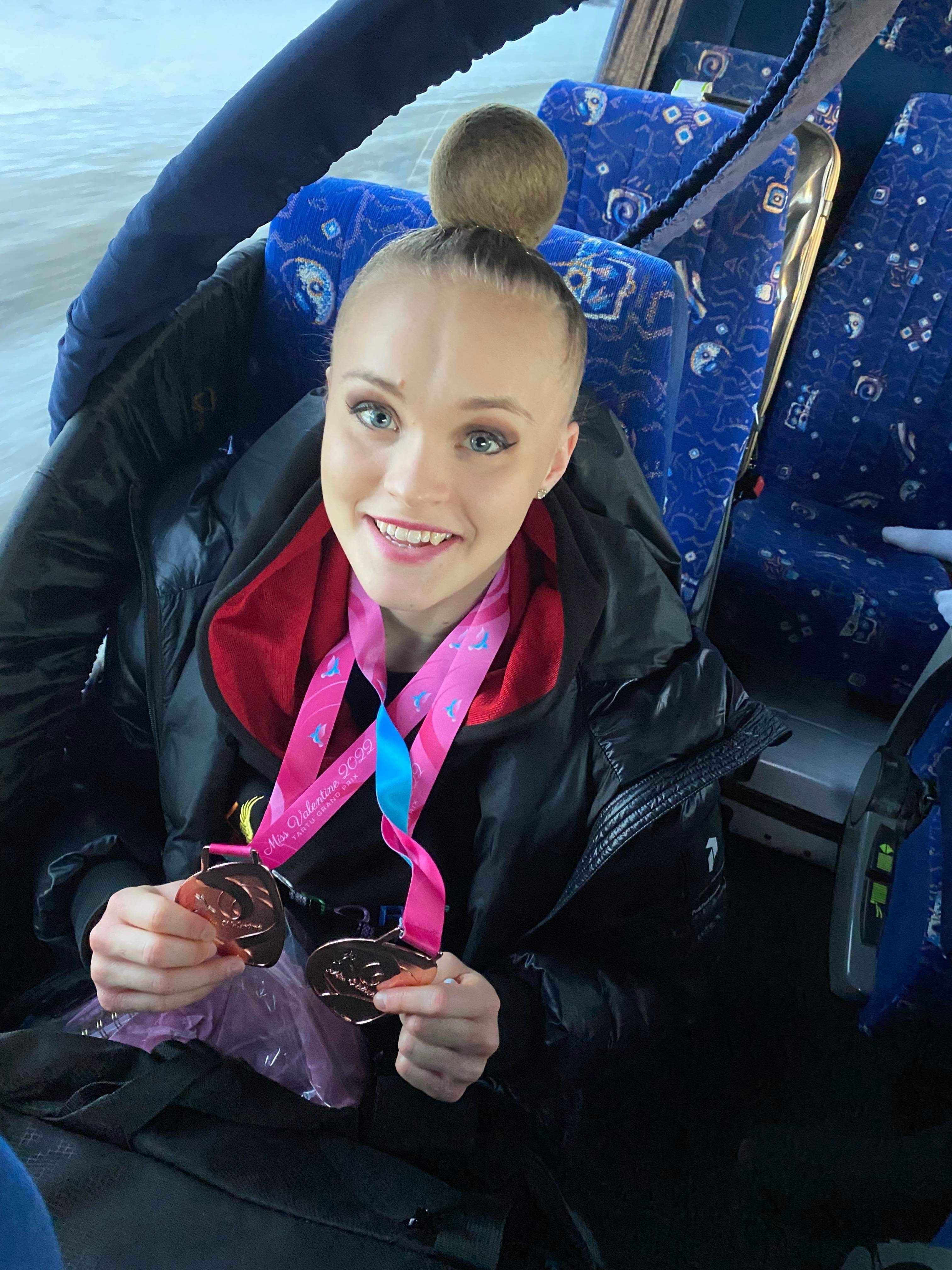 Emma i bussen med sina medaljer