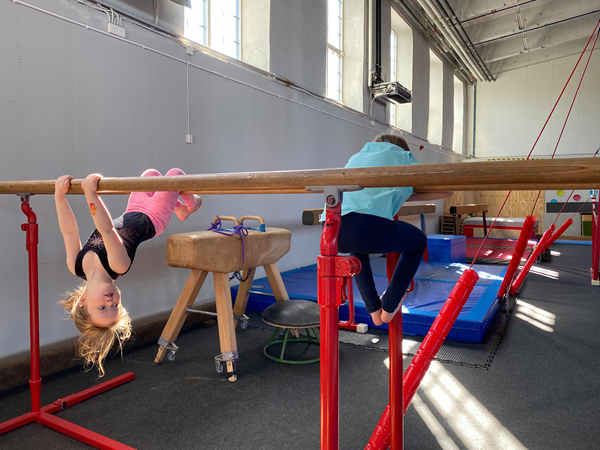Barn klättrar på gymnastikutrustning i gymnastiksal