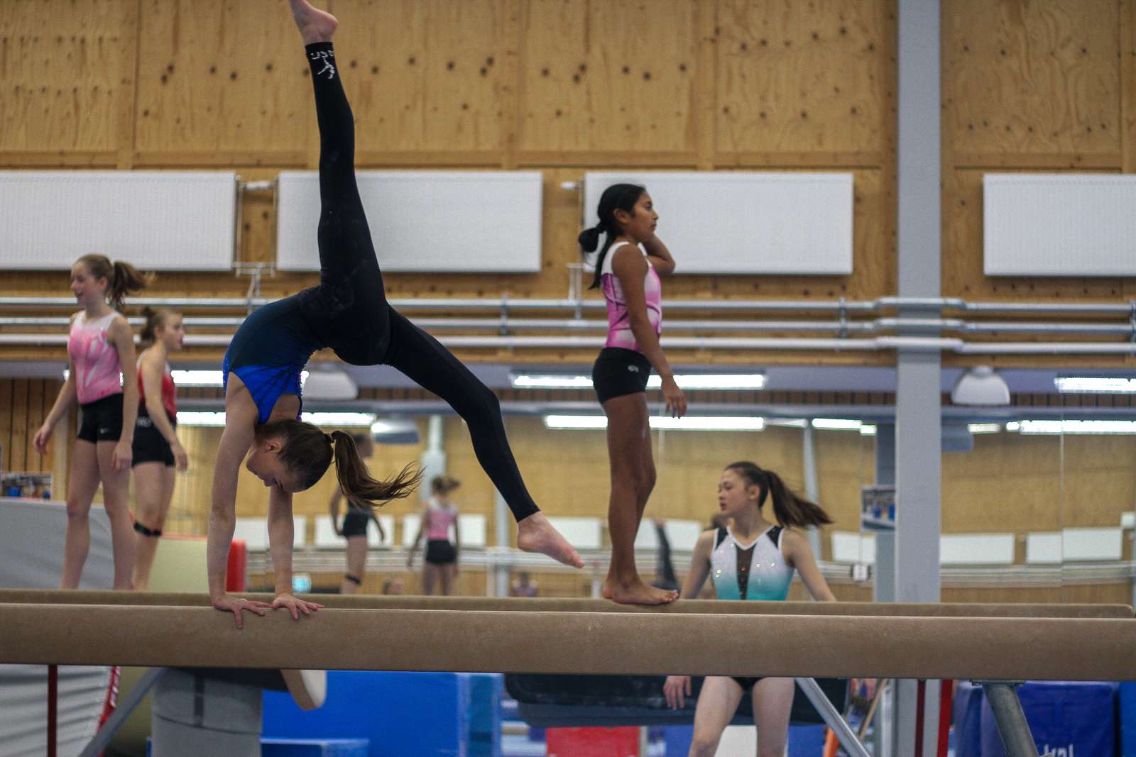 Gymnaster gör övningar på bom