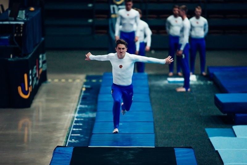 Truppgymnast Didrik på tävling springer mot kameran